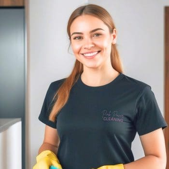 Professional Biweekly Cleaning Smiling Pink Power Cleaning team member holding a cleaning cloth, ready to provide professional cleaning services.
