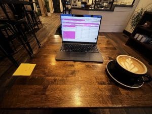 Pink Power Cleaning & Pest Control mobile office setup at Purebred Coffee in Downtown Troy, Ohio. Local business operations with flexible workspaces and community engagement.